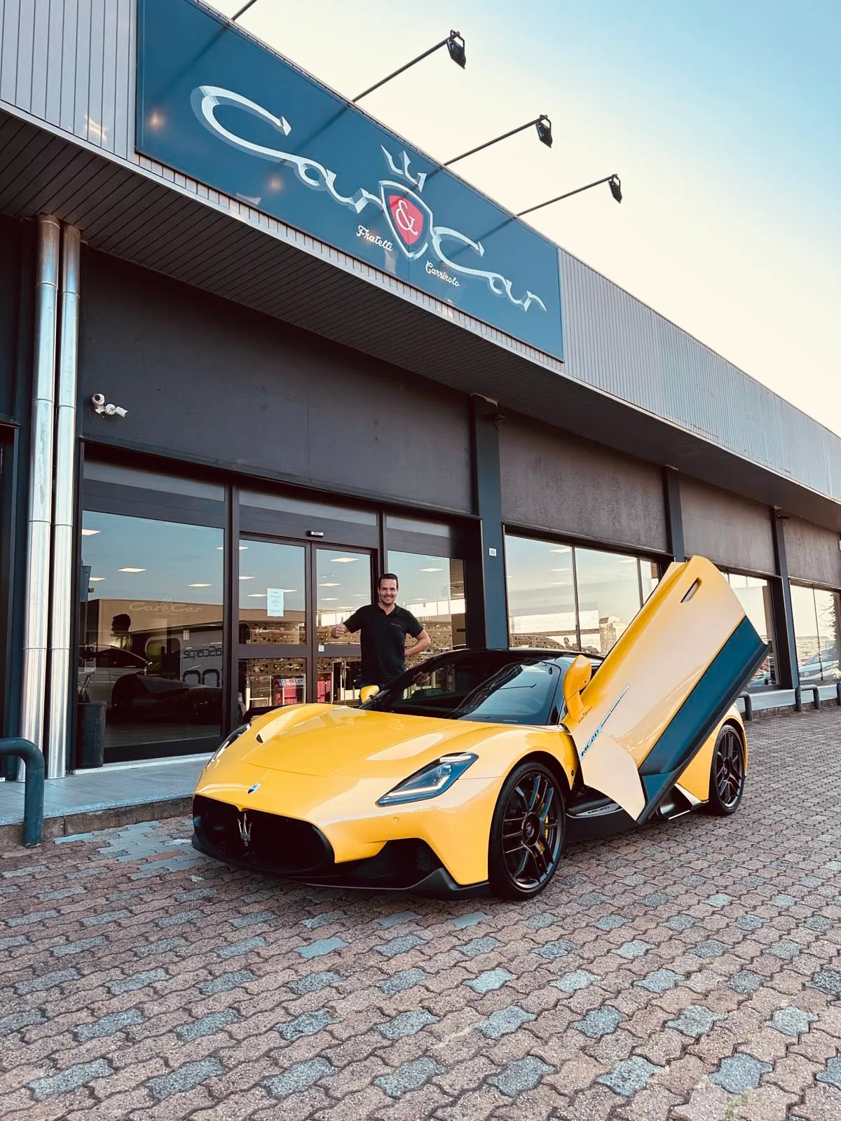 Een gele Maserati MC20 overgedragen aan de klant bij een garagehouder in Italië
